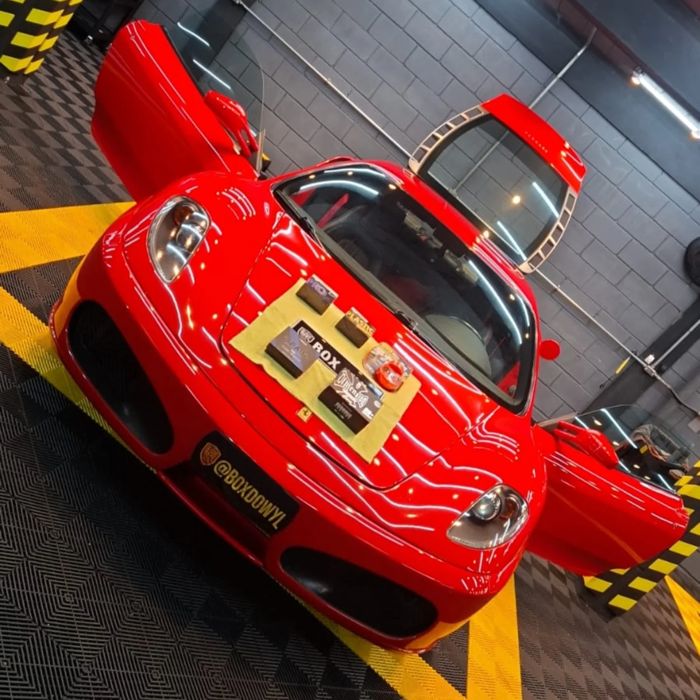 Carro vermelho de portas abertas no estúdio